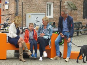 Hella van der Wijst met passanten op de GHL-bank in Sluis