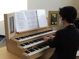 Connie van Hermon achter het Content 323-orgel waarin o.a. de disposities van de orgels van de Sint Laurenskerk in Rotterdam en de kathdraal van Caen zijn verwerkt. 